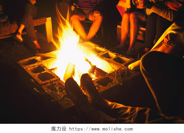 一群朋友坐在篝火旁一群朋友坐在篝火附近，在夜晚